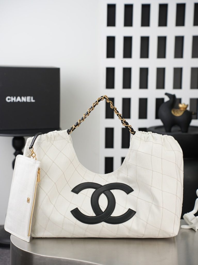 💼𝑪𝒉𝒂𝒏𝒆𝑰 𝟐𝟔𝑺 | 帆布沙滩托特𝒕𝒐𝒕𝒆👜  ✨ 奶白色帆布托特包，面料挺括有型，菱格绗缝工艺自带松弛质感。可调节穿皮金属链带，搭配同色系拉链附包，内里衬里细节精致。正面logo标识采用黑色亮面牛皮材质，边缘做了工整的包边缝线处理，皮革表面光滑细腻，自带哑光柔亮质感，与奶白色帆布形成强烈的黑白撞色对比，辨识度拉满。大容量设计轻松装下日常用品，黑白金配色高级又百搭，是通勤与出游的实用单品。款号：AS6191白色黑字尺寸：𝟐𝟎*𝟒𝟑*𝟏𝟕𝒄𝒎带包装盒-newbee