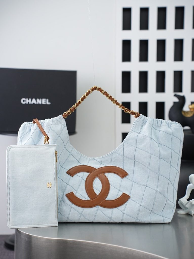💼𝑪𝒉𝒂𝒏𝒆𝑰 𝟐𝟔𝑺 | 帆布沙滩托特𝒕𝒐𝒕𝒆👜💜独家背景💜实物实拍顶级质量✨清爽浅蓝菱格牛仔托特包☁️，甄选柔和浅蓝牛仔面料搭配利落菱格车线，正面饰有焦糖色皮质双C标识🤎，搭配穿皮编织金属链条肩带✨，风格休闲松弛；附赠同面料可拆卸拉链内袋💼，内里设有品牌产地皮标，大敞口仓体储物空间宽裕📦，可收纳通勤文件、出行杂物等大件物品，可搭配延长皮带切换背携方式🔗，春夏穿搭适配度拉满🌿，是日常通勤、周末出游都很适配的慵懒氛围感单品☀️。  款号：AS6191蓝色棕字  尺寸：𝟐𝟎𝟒𝟑𝟏𝟕𝒄𝒎带包装盒-newbee