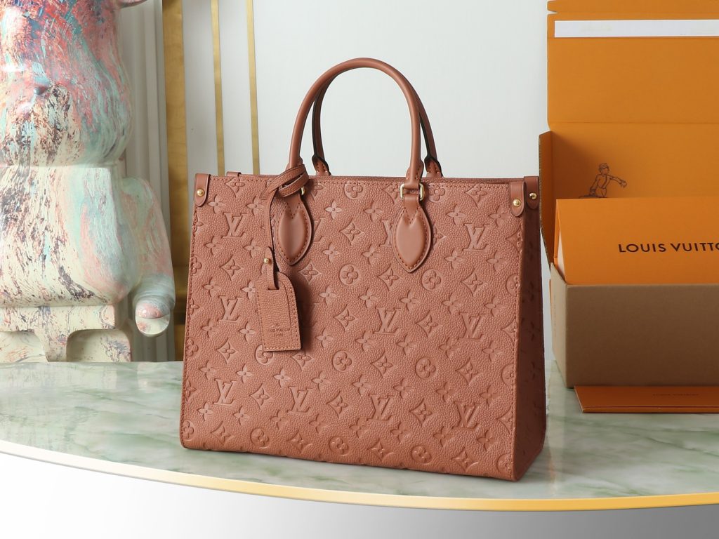  OnTheGo 中号手袋以复古硬箱为灵感，为品牌标志性 Monogram Empreinte 皮革渲染浓郁色调，搭配工致金属件。充裕构型可容纳 13 寸笔记本电脑，另有多重内袋方便存放物品。长短手柄实现多种背携方式。尺寸35.0 x 27.0 x 14.0 厘米 (长 x 高 x 宽)-newbee